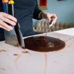 Person mäter temperaturen i smält choklad med digital termometer