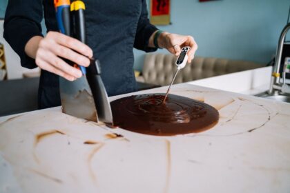 Person mäter temperaturen i smält choklad med digital termometer